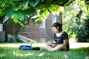 Girl sitting and reading under a tree.